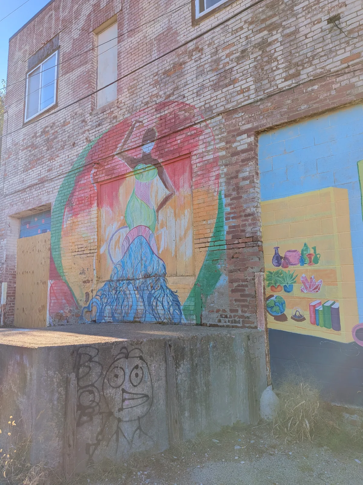 Colorful murals painted across an old brick warehouse wall in the Warehouse District