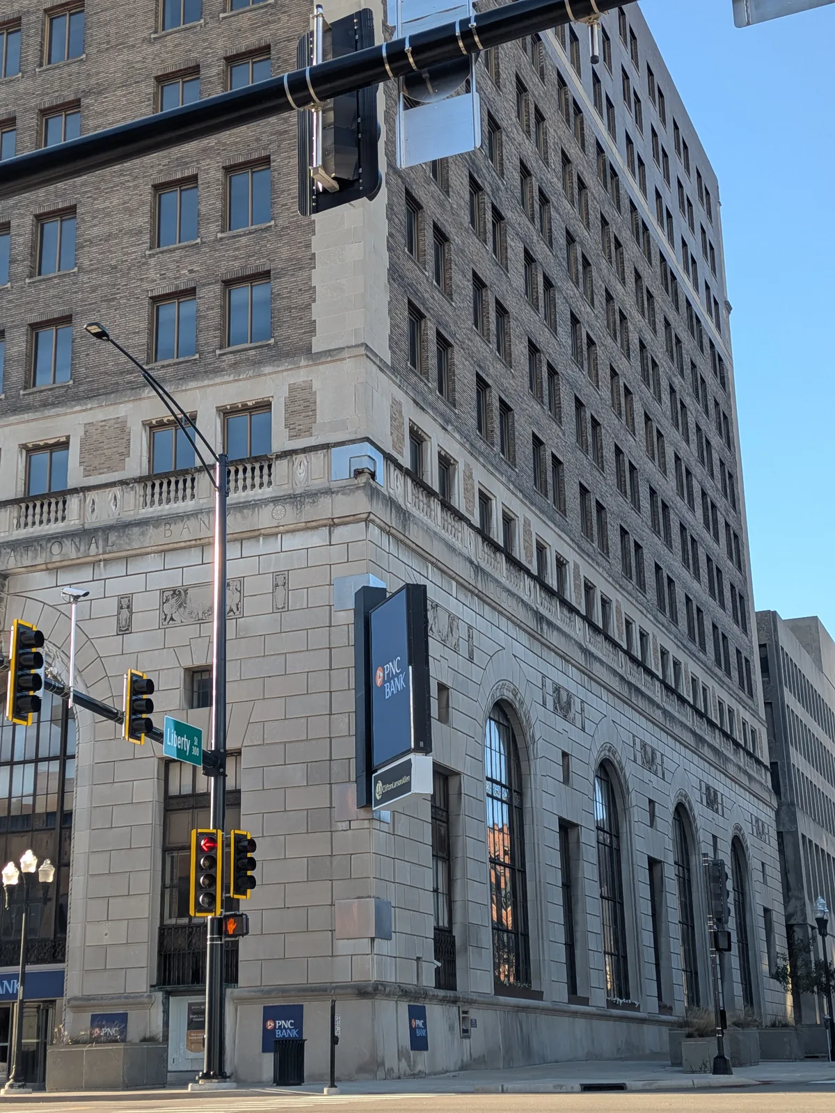 A carved-stone 1920s bank tower with arched windows on a downtown corner