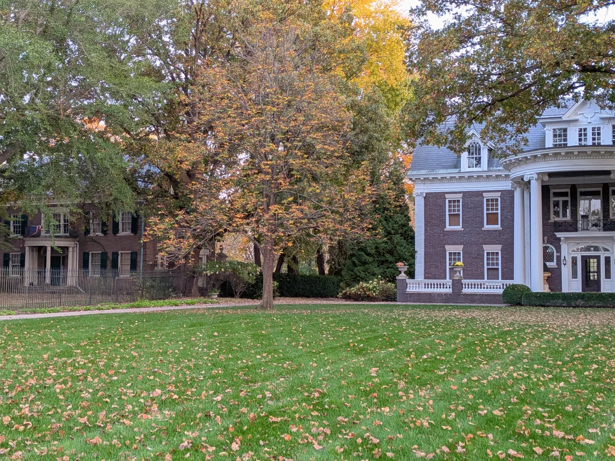 Two grand brick houses, one with tall white columns and a curved portico